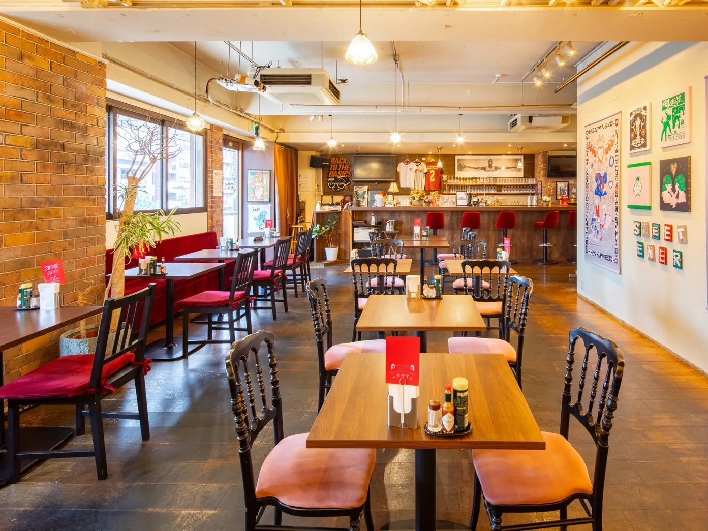 目黒区の喫茶店『アート喫茶フライ』のレンガ壁と木のテーブルが並ぶ店内